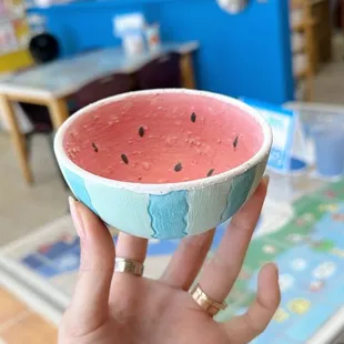 a hand holding a watermelon bowl