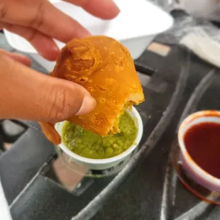 a hand holding a sandwich with guacamole