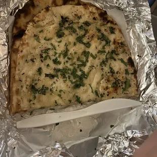 One piece of naan with generic plastic knife for comparison. A single order comes with two pieces.