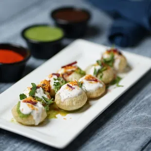 a plate of appetizers and sauces