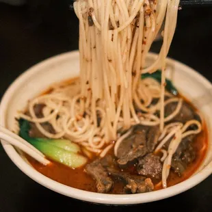 a plate of noodles with meat and vegetables