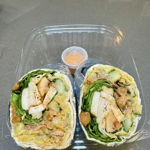 two burritos in a plastic container