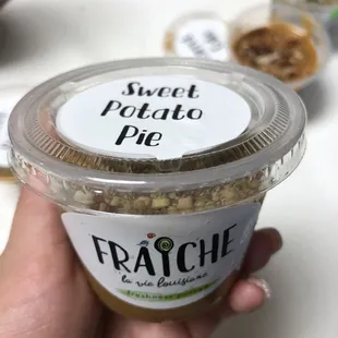 a hand holding a cup of fraiche