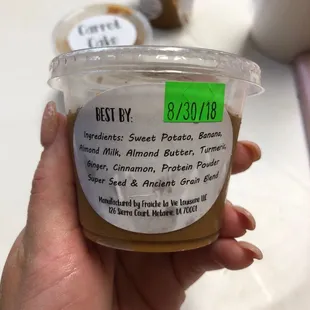 a hand holding a cup of honey