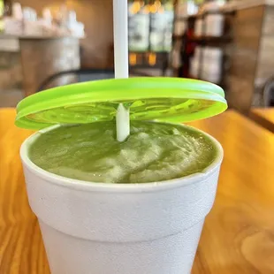 a green smoothie in a plastic cup