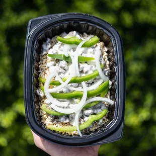 a hand holding a container of food