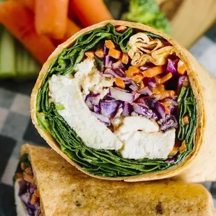 a wrap with vegetables and a dipping sauce