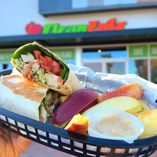 a hand holding a basket of food