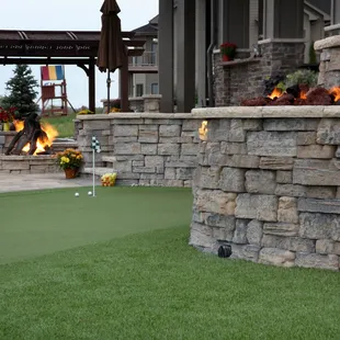 a golf course with a fire pit in the background