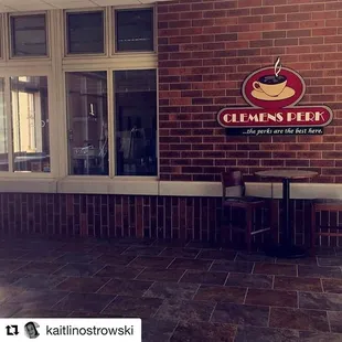 a coffee shop with a brick wall