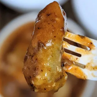 Malfatti outside, they come in a takeout container filled with red sauce.