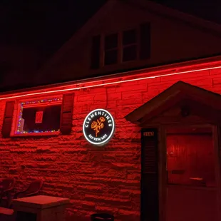 a neon sign on a brick building