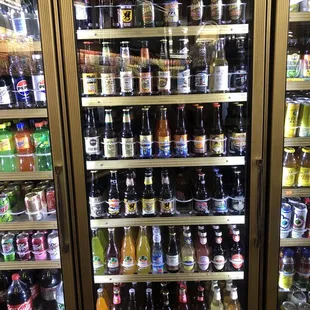 Refrigerated case with so many different root beers and other non alcoholic drinks.