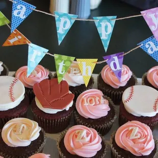a variety of cupcakes with baseball decorations