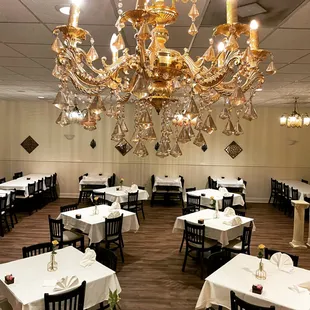 a dining room with chandelier and tables