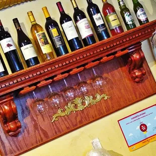 a shelf of wine bottles and glasses