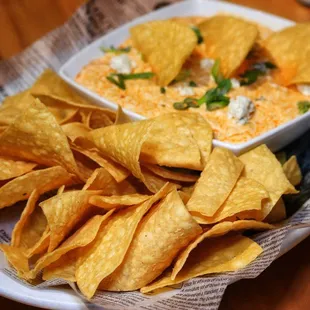 a plate of chips and a bowl of dip