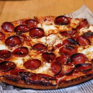 a pepperoni pizza on a napkin