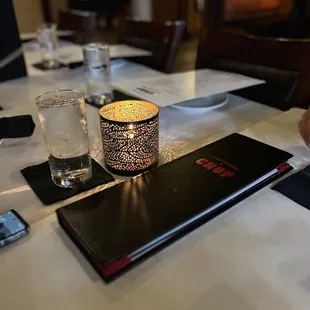 a table setting with a candle and menu