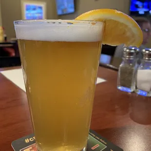 a glass of beer with a slice of lemon