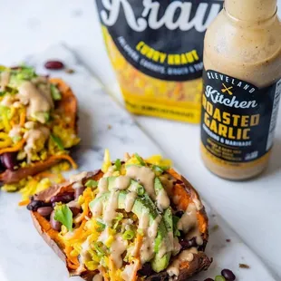 two loaded sweet potatoes on a cutting board
