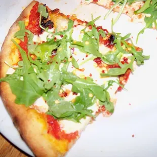 Pizza Claudia- Tomato sauce, fresh mozzarella, sun dried tomatoes, arugula and a touch of garlic oil
