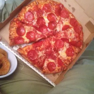 a box of pepperoni pizza and a plate of doughnuts