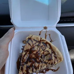 a slice of pizza in a styrofoam container