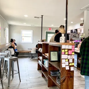 a woman standing at a counter in a coffee shop