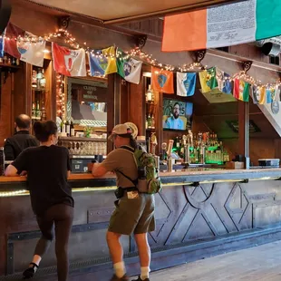 two people standing at the bar