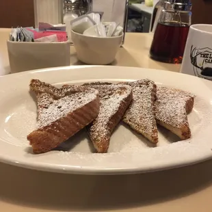 a plate of french toast with powdered sugar