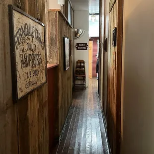 a narrow hallway with a sign on the wall
