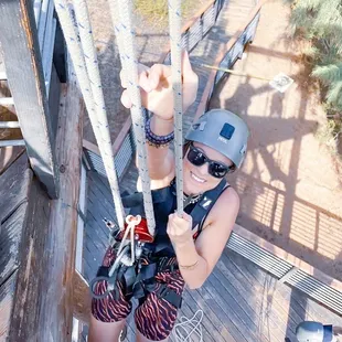 Climbing one of the challenges in between the zip-lining.