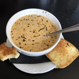 a bowl of soup and two pieces of bread