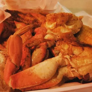 crab legs and carrots in a styrofoam container