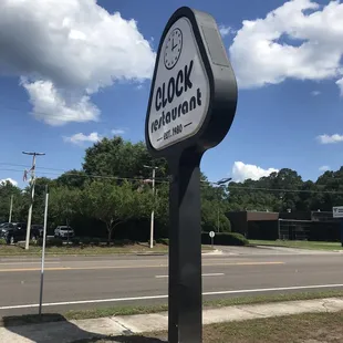 a clock sign on the corner of a street
