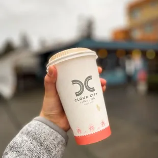 a hand holding a cup of coffee