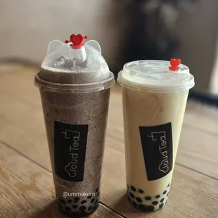 two cups of bubble tea on a wooden table