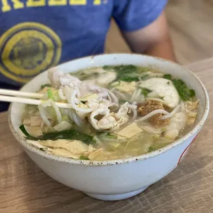 a person holding chopsticks in a bowl