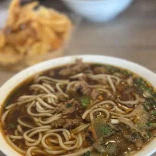 a bowl of noodles with meat and vegetables