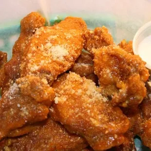 a plate of fried chicken wings with a side of ranch dip