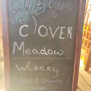 a blackboard with a sign that says welcome to clover meadows winery