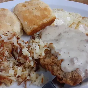 Chicken fried steak with fried eggs, biscuits and hash browns.  No flavor.
