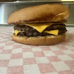 a cheeseburger on a checkered tablecloth