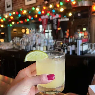 a hand holding a glass of margarita