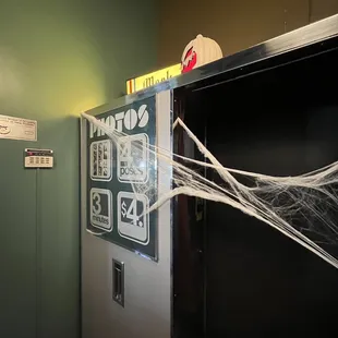 a vending machine with spider webs