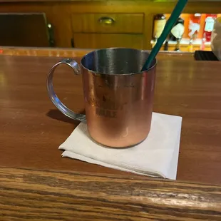 a copper mug with a green spoon