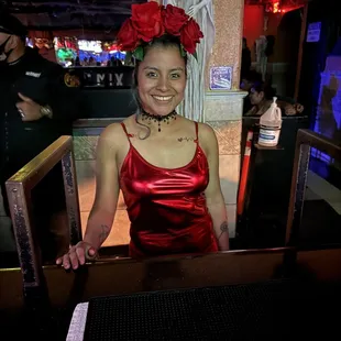 a woman in a red dress at a bar