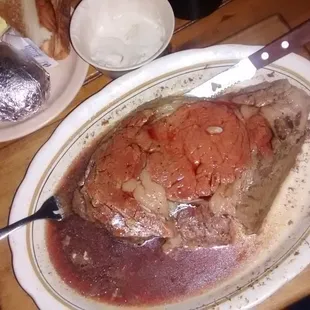 a plate of meat with sauce and bread
