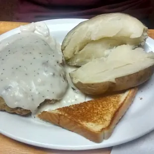 a plate of food with a potato and gravy